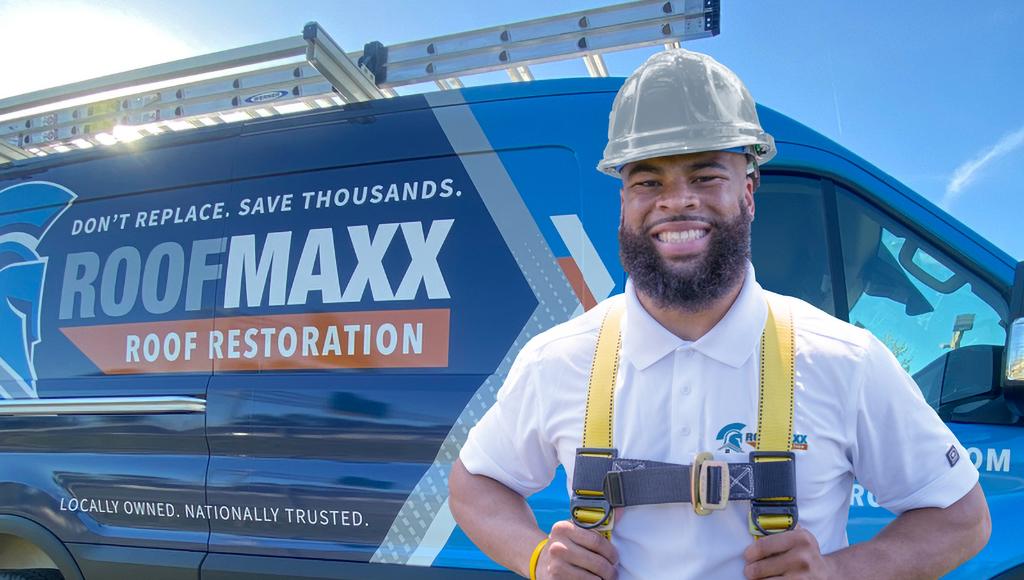Roof Maxx dealer smiles next to a branded truck