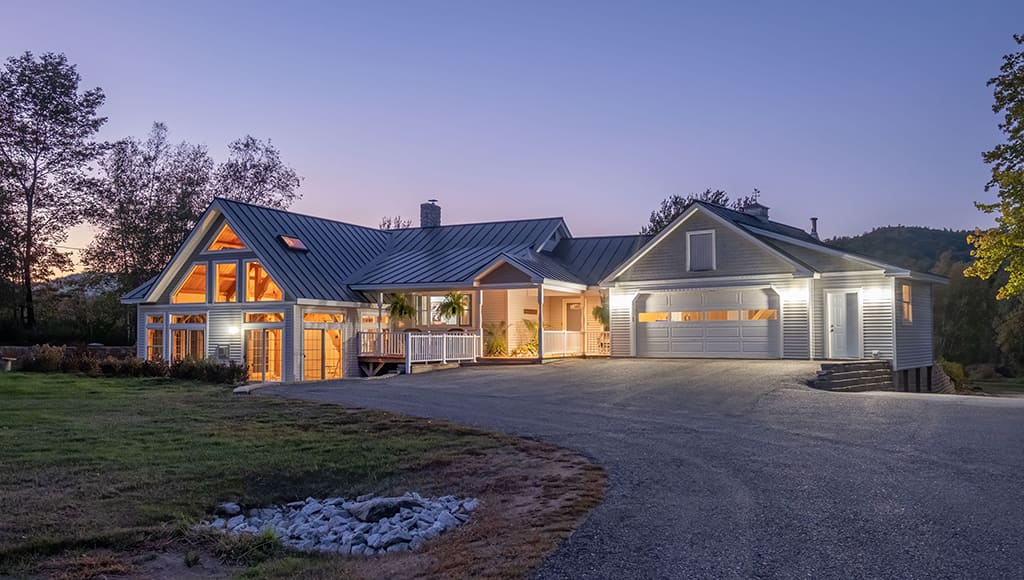 A ranch-style home with engineered wood siding shown in twilight