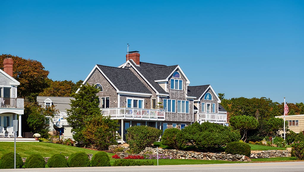 A beautiful home by the sea with sailboats in the windows.