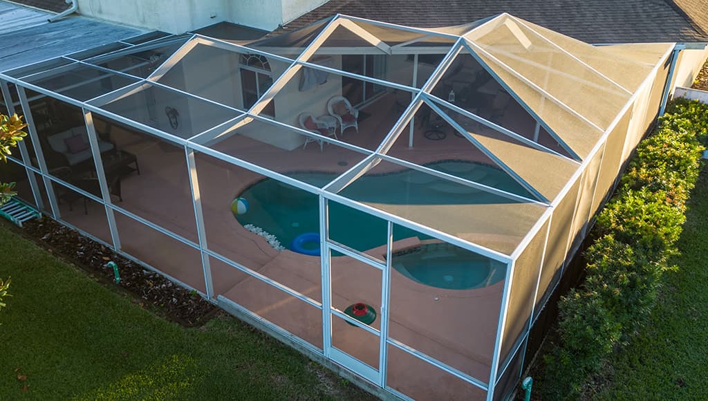 An enclosed pool surrounded by window panels with permanent screens.