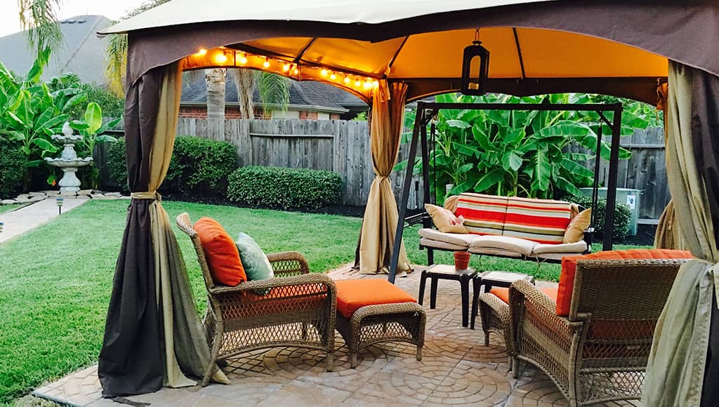 A pretty gazebo tent with thick, outdoor curtains.
