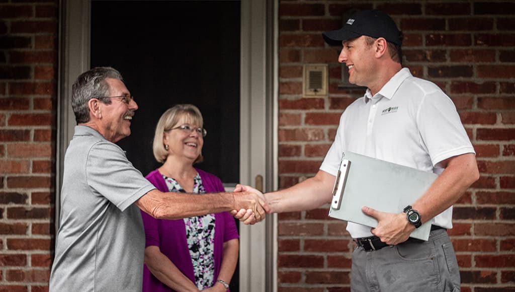 A Roof Maxx employee greets a happy customer after the job is done.