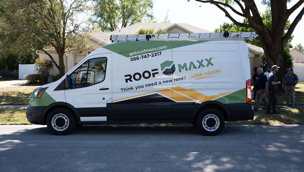 A Roof Maxx truck parked in front of a customer's home.