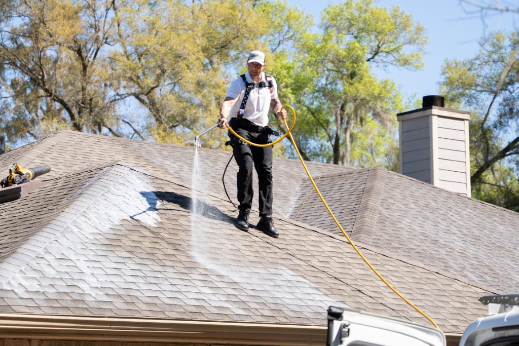 A Roof Maxx employee sprays Roof Maxx on a customer's roof.