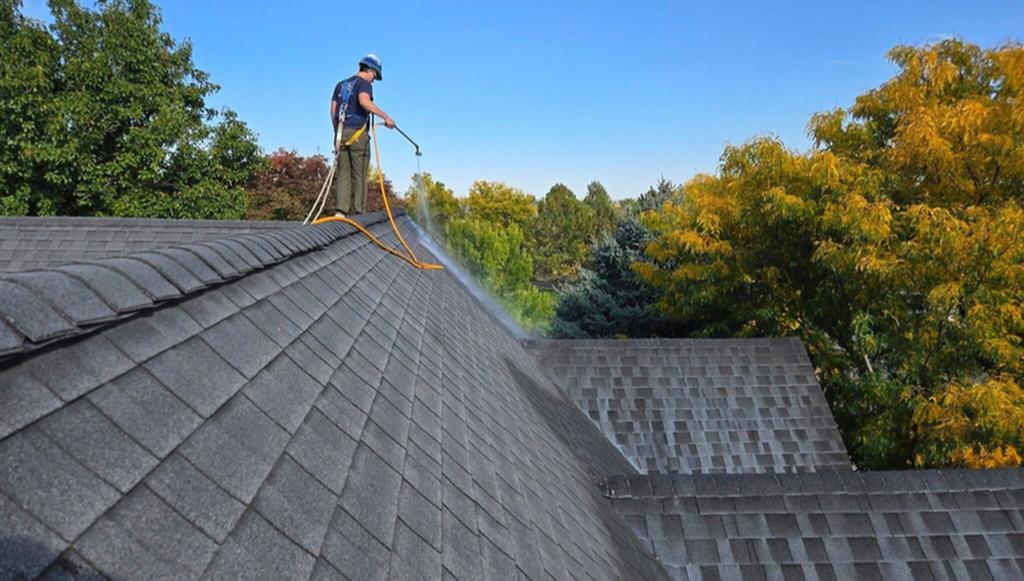 A Roof Maxx dealer sprays the treatment onto a customer's asphalt shingle roof.