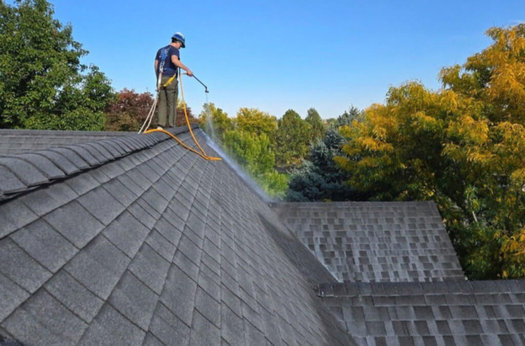 A Roof Maxx dealer sprays the treatment onto a customer's asphalt shingle roof.