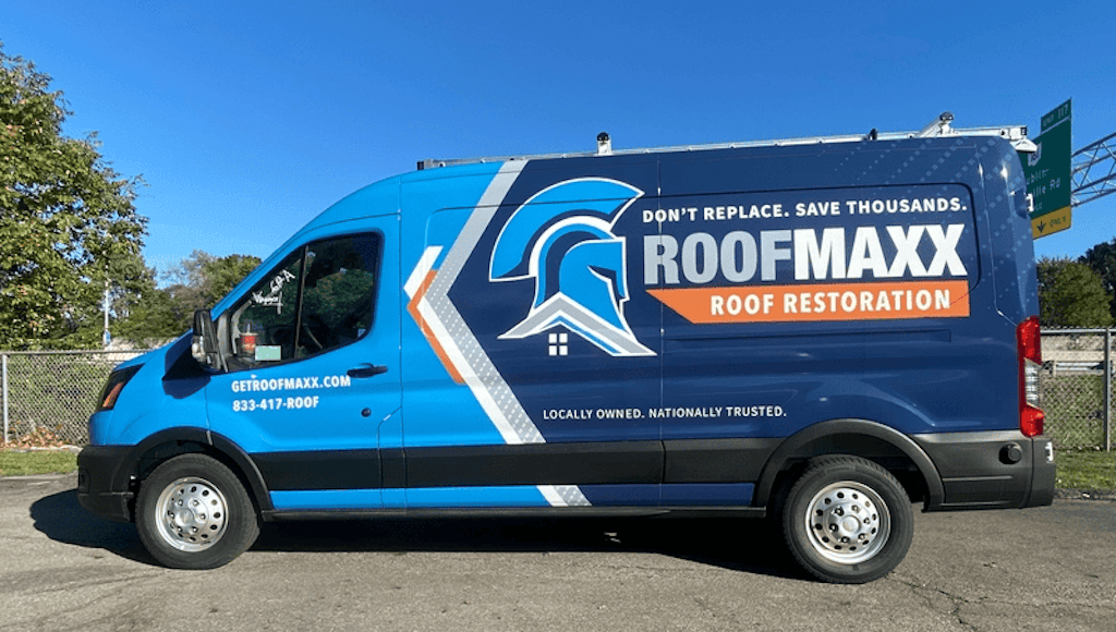 A blue branded Roof Maxx van with the words Don't Replace Save Thousands Roof Maxx Roof Restoration on the side.